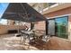 Relaxing patio with a dining table set, chaise lounges, and shade from a large umbrella at 6803 E Main St # 1106, Scottsdale, AZ 85251