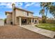 Exterior of a home with a covered patio, a well-manicured lawn, and tall palm trees at 7009 W Taro Ln, Glendale, AZ 85308