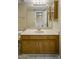 Well-lit bathroom featuring a single vanity, cabinets, and a large mirror with an open doorway at 7009 W Taro Ln, Glendale, AZ 85308