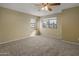 Neutral bedroom showcasing large windows and plush carpeting with a ceiling fan at 7009 W Taro Ln, Glendale, AZ 85308