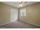 Cozy bedroom features carpet, a closet, and natural light through a window with ceiling fan at 7009 W Taro Ln, Glendale, AZ 85308