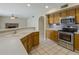 Bright kitchen with wooden cabinets, stainless steel appliances, and tiled flooring at 7009 W Taro Ln, Glendale, AZ 85308