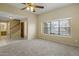 Cozy living room with stairs, entrance, large window, and tile and carpet flooring at 7009 W Taro Ln, Glendale, AZ 85308
