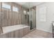 Luxurious bathroom featuring a soaking tub, tiled shower, and wood-look tile flooring, creating a spa-like retreat at 7138 W Kent Dr, Chandler, AZ 85226
