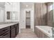 Elegant bathroom featuring a soaking tub, tiled shower, and wood-look tile flooring, creating a relaxing retreat at 7138 W Kent Dr, Chandler, AZ 85226