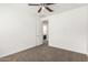 A carpeted bedroom features neutral walls, a ceiling fan, and an adjoining bathroom at 7138 W Kent Dr, Chandler, AZ 85226
