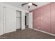A carpeted bedroom features a closet, ceiling fan, and geometric accent wall at 7138 W Kent Dr, Chandler, AZ 85226