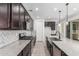 Spacious kitchen featuring stainless steel appliances, granite countertops, and dark cabinets with herringbone backsplash at 7138 W Kent Dr, Chandler, AZ 85226