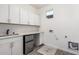 A bright laundry room features white cabinets, a utility sink, and ample counter space at 7138 W Kent Dr, Chandler, AZ 85226