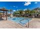 Community pool features a splashpad with sprinklers, with lounge chairs, tables and umbrellas at 7138 W Kent Dr, Chandler, AZ 85226