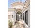 Stunning home entrance featuring an arched doorway, black trim windows, and manicured landscaping at 7670 E Sierra Vista Dr, Scottsdale, AZ 85250