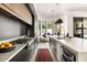 Modern kitchen with stone countertops, black cabinets, and stainless steel appliances at 7670 E Sierra Vista Dr, Scottsdale, AZ 85250