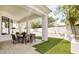 Outdoor covered patio with dining table and chairs, green turf, bench seating and decorative landscaping at 7670 E Sierra Vista Dr, Scottsdale, AZ 85250