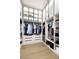 Organized walk-in closet with drawers, clothing rods, shelving, and upper cabinets with obscured glass doors at 7670 E Sierra Vista Dr, Scottsdale, AZ 85250