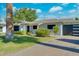 Attractive single-story home with lush landscaping and a contemporary garage door at 8319 E Indianola Ave, Scottsdale, AZ 85251