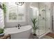 Bright bathroom featuring a freestanding soaking tub, walk-in shower, plantation shutters, and modern finishes at 851 E Deer Creek Rd, Phoenix, AZ 85048
