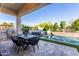 Outdoor patio with an outdoor kitchen, dining area, pool and desert landscaping at 851 E Deer Creek Rd, Phoenix, AZ 85048