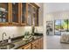 Bar area with wood cabinets, granite countertop, and a view into the bedroom at 10040 E Happy Valley Rd # 479, Scottsdale, AZ 85255