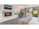 Cozy bedroom with a fireplace, built-in shelves, neutral carpet, and access to the patio at 10040 E Happy Valley Rd # 479, Scottsdale, AZ 85255