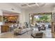 Open-concept living room with bar area, seamlessly connected to an outdoor patio and pool area at 10040 E Happy Valley Rd # 479, Scottsdale, AZ 85255