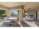 Covered patio with dining and seating areas, seamlessly connected to the pool and outdoor fireplace at 10040 E Happy Valley Rd # 479, Scottsdale, AZ 85255
