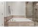 Modern bathroom features a soaking tub and glass-enclosed shower with neutral tile surround at 10260 E White Feather Ln # 1022, Scottsdale, AZ 85262