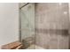 Elegant walk-in shower with tiled walls, glass door, and stylish storage basket at 10260 E White Feather Ln # 1022, Scottsdale, AZ 85262