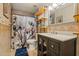 Nicely tiled bathroom featuring modern vanity, decorative mirror and stylish shower curtain at 10837 W Cottonwood Ln, Avondale, AZ 85392