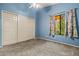 Cozy bedroom with light blue walls, carpet, and double door closet at 10837 W Cottonwood Ln, Avondale, AZ 85392