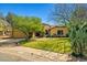 Charming single-story home featuring a well-manicured lawn, mature trees, and desert landscaping at 10837 W Cottonwood Ln, Avondale, AZ 85392