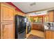 Updated kitchen features black appliances, granite countertops, and natural wood cabinets at 10837 W Cottonwood Ln, Avondale, AZ 85392