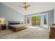 Spacious main bedroom featuring ceiling fan, carpet, and large sliding glass doors to the outside at 10837 W Cottonwood Ln, Avondale, AZ 85392