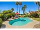 Inviting backyard pool with lush tropical landscaping, lounge chairs, and a red umbrella for shade at 10837 W Cottonwood Ln, Avondale, AZ 85392