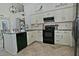 Open kitchen features white cabinetry, black appliances, granite counters, and tile floors at 10939 N 111Th St, Scottsdale, AZ 85259