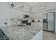 Spacious kitchen features granite countertops, white cabinets, stainless appliances and modern pendant lighting at 10939 N 111Th St, Scottsdale, AZ 85259