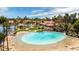 Scenic aerial shot of a lagoon-style pool featuring a sandy beach, turquoise water, lush landscaping, and lounge chairs at 1110 N Gull Haven Ct, Gilbert, AZ 85234