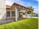 Enjoy a backyard with a covered patio, lush artificial turf, and stylish exterior lighting for relaxation and entertainment at 1110 N Gull Haven Ct, Gilbert, AZ 85234