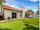 Beautiful backyard featuring a putting green, lush artificial turf, and a well-maintained exterior at 1110 N Gull Haven Ct, Gilbert, AZ 85234