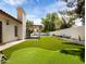 An expansive backyard with a putting green, artificial turf, and a covered patio, perfect for outdoor living at 1110 N Gull Haven Ct, Gilbert, AZ 85234