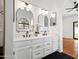 Bright bathroom with dual sinks, white cabinetry, arched mirrors, and modern lighting fixtures at 1110 N Gull Haven Ct, Gilbert, AZ 85234