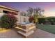 Outdoor jacuzzi on a stone platform, surrounded by lush greenery and desert landscaping with beautiful sunset views at 11339 E Beck Ln, Scottsdale, AZ 85255