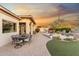 Outdoor patio featuring seating, a dining area, and a landscaped backyard with sunset views at 11339 E Beck Ln, Scottsdale, AZ 85255