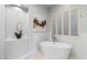 Modern bathroom with a standalone soaking tub, stylish shutters, and decorative art for a spa-like experience at 11339 E Beck Ln, Scottsdale, AZ 85255