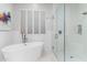 Bright bathroom featuring a soaking tub, glass-enclosed shower, and white tile, creating a clean design at 11339 E Beck Ln, Scottsdale, AZ 85255