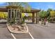 Inviting entry gate with stone accents, desert landscaping, and a water feature at 11339 E Beck Ln, Scottsdale, AZ 85255