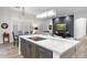 Open-concept kitchen and living room featuring modern lighting, island cooktop, and hardwood-style floors at 11339 E Beck Ln, Scottsdale, AZ 85255