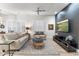 Comfortable living room with neutral tones, large TV, decorative rug, and ample natural light through window shutters at 11339 E Beck Ln, Scottsdale, AZ 85255