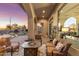 Covered outdoor patio featuring a comfortable seating area, fire pit, and views of the backyard and desert landscape at 11339 E Beck Ln, Scottsdale, AZ 85255