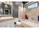 Tiled bathroom featuring a built-in bathtub and sleek vanity for a clean, modern look at 11827 S Montezuma Ct, Phoenix, AZ 85044