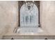 Soaking tub under arched window with decorative shutters and chandelier at 11827 S Montezuma Ct, Phoenix, AZ 85044